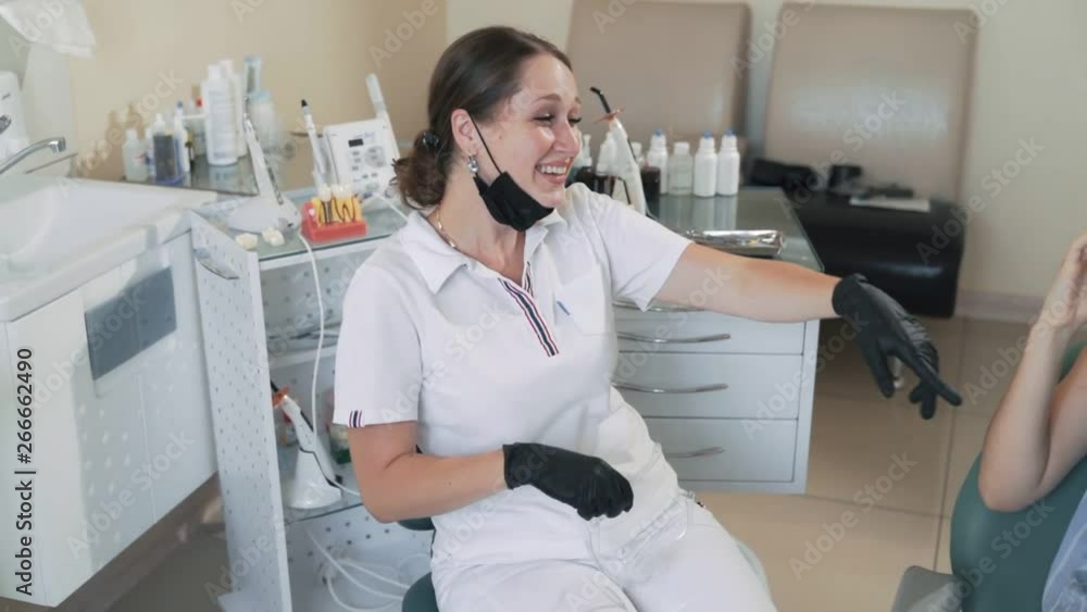 Dentist laughs and smiles with patient in dental clinic, slow motion. Funny video Dentist laughs and smiles with patient in dental clinic, slow motion. Funny video