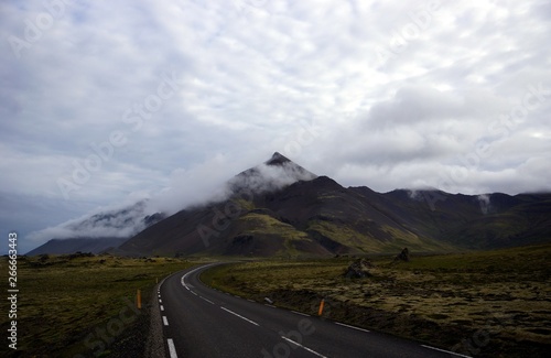 Road next to cloud covered mountain range