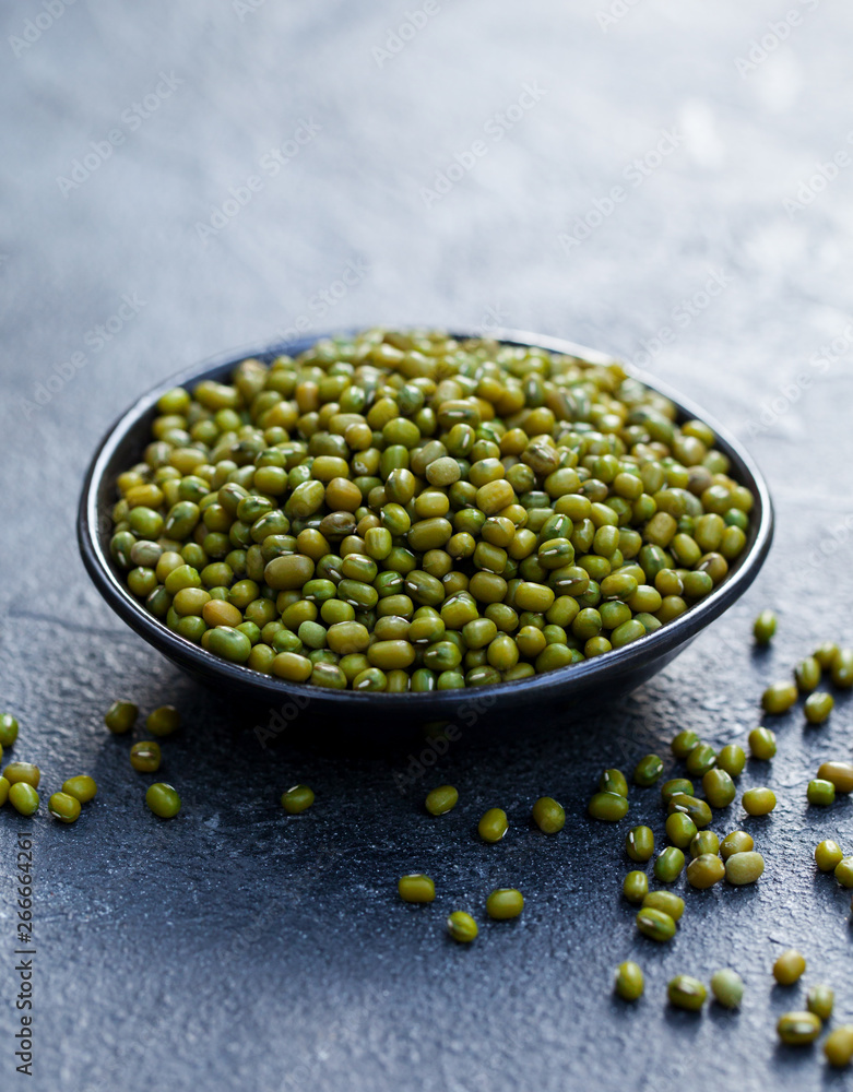 Mung bean, green moong dal in wooden bowl. Copy space. Grey slate background. Mung bean, green moong dal in wooden bowl. Copy space. Grey slate background.