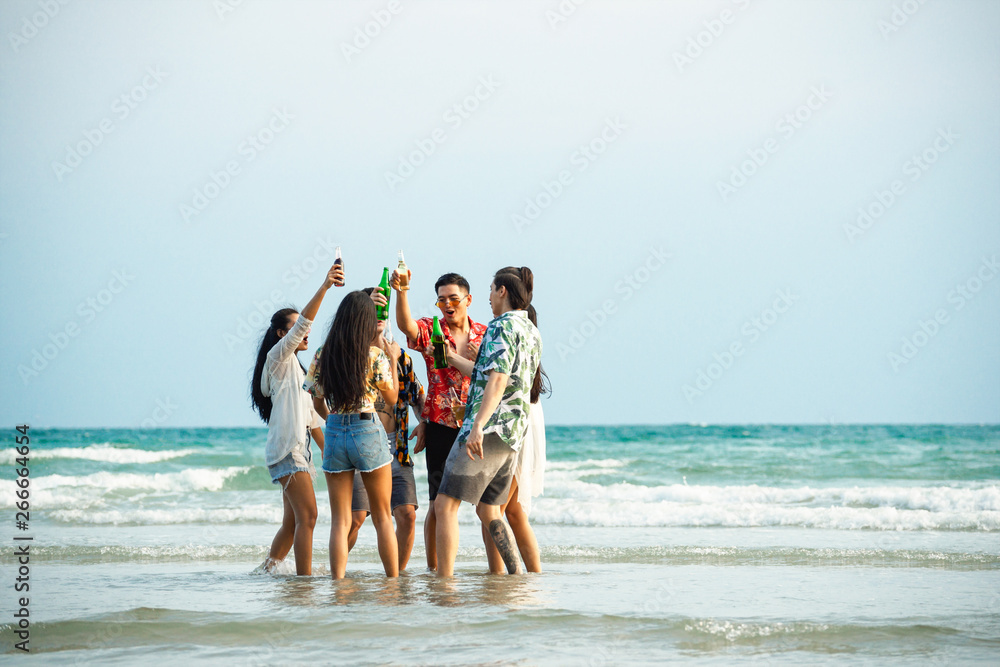 A group of friends who party and play fun on the beach. - obrazy, fototapety, plakaty 