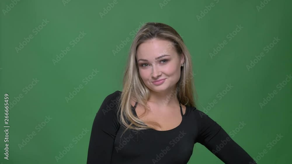 Joyful businesswoman in black blouse gesturing okay sign to show everything is good into camera at green background. Joyful businesswoman in black blouse gesturing okay sign to show everything is good into camera at green background.