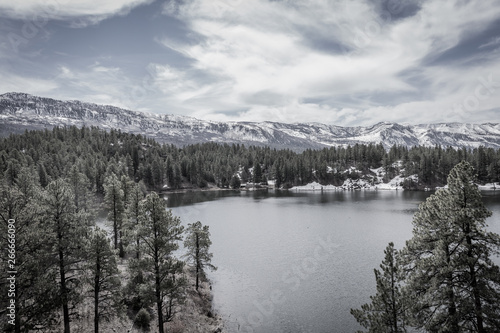 A fresh water lake is surrounded by a forest of Pine trees and towering snow capped mountains in this wilderness area outside of Durango, Colorado. Natural beauty everywhere you look is good for you © Leslie Rogers Ross
