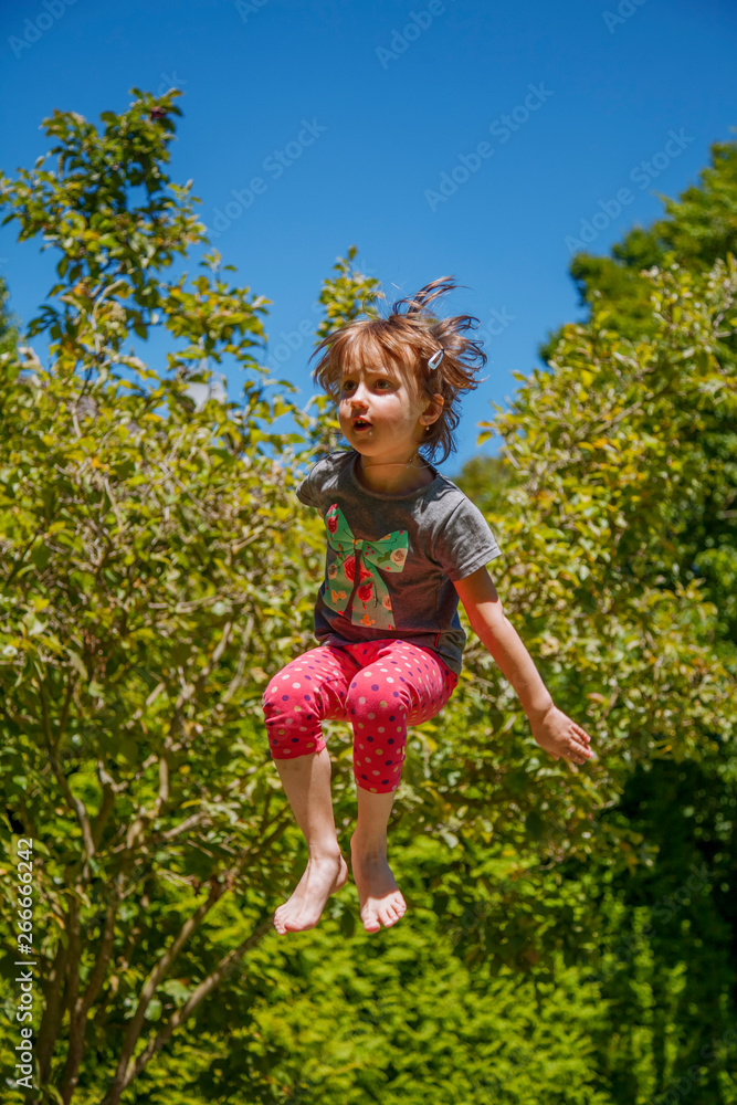 Rest outdoors. Little cute child girl jumping for joy on a trampoline. Rest outdoors. Little cute child girl jumping for joy on a trampoline.