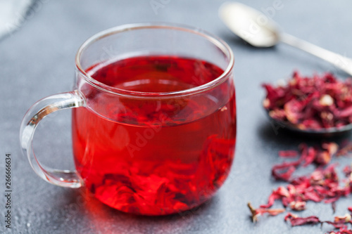 Hibiscus tea in glass cup. Grey background. Close up.
