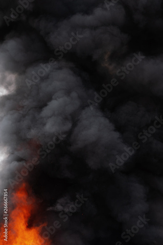 Black motion clouds of strong red fire smoke covered sky. Defocus and motion blur from fire and high temperature from flames. Atmospheric and smoke dispersion.