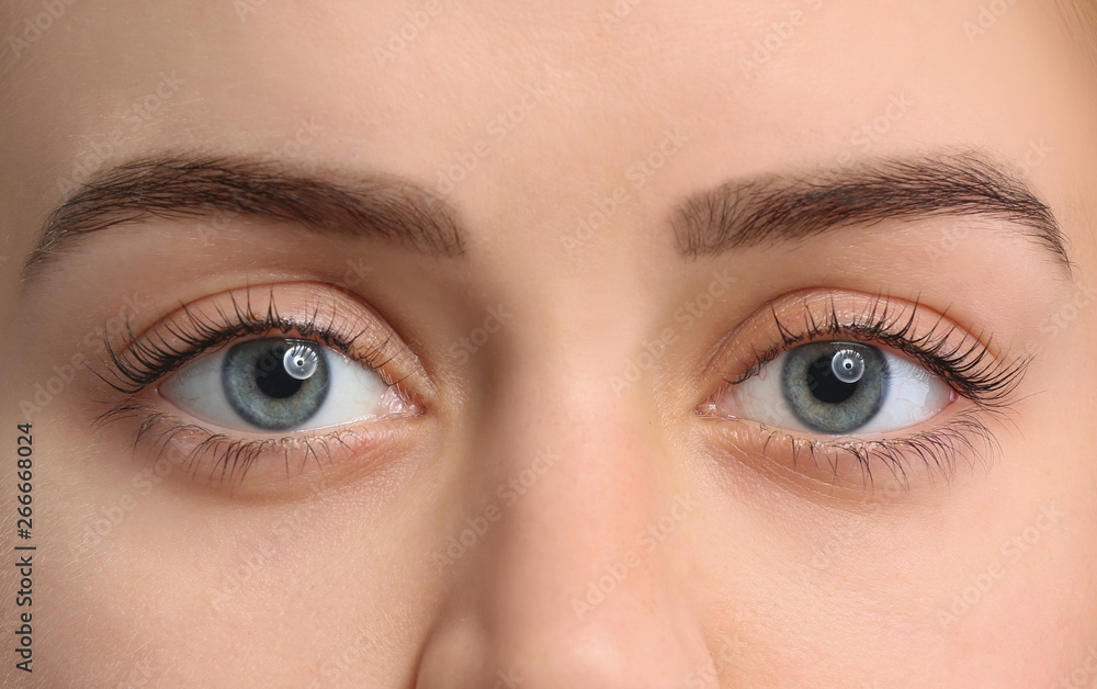 Fototapeta premium Piękna młoda kobieta po laminowaniu rzęs na białym tle, zbliżenie
