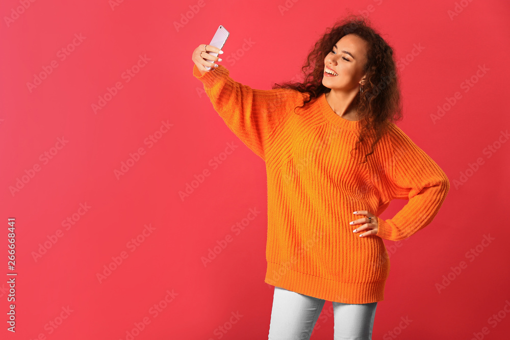 Beautiful young woman taking selfie on color background Beautiful young woman taking selfie on color background