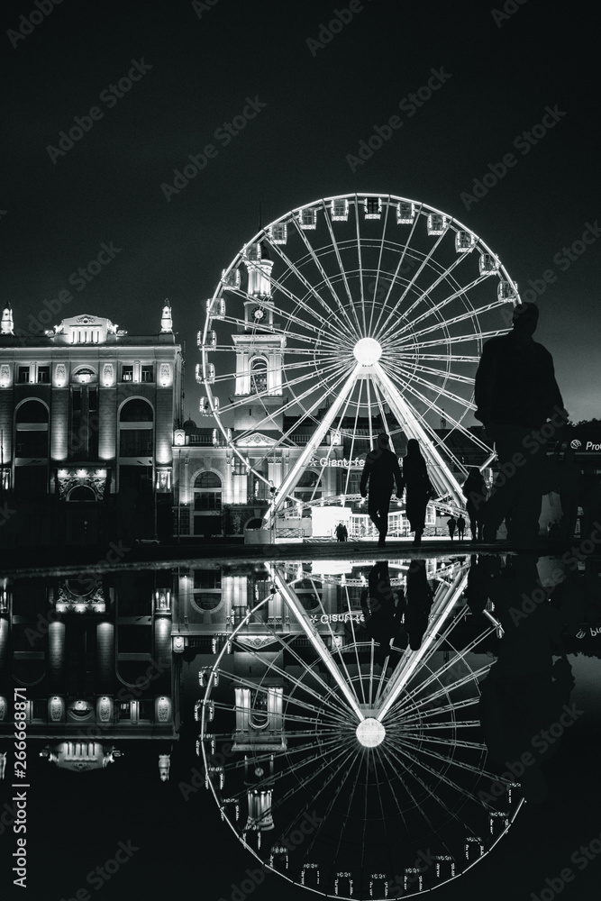 Fototapeta premium People siluette in front of Black and white Ferris wheel at European night. Kyiv, Ukraine