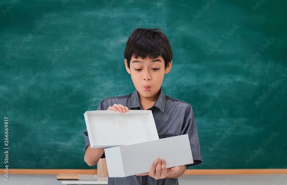 Asian happy school boy excited and open box on black board background with copy space.Creative education of kid student concept. Asian happy school boy excited and open box on black board background with copy space.Creative education of kid student concept.