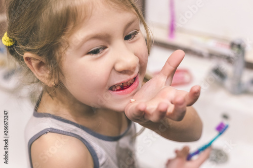 Cute little child has just lost the first milk tooth.