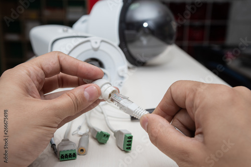 Hand inserting the Ethernet cable into the network security camera, equipment manipulation