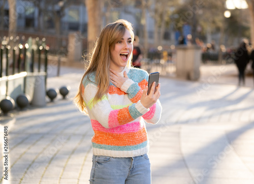 Attractive happy young woman making a video call or video for blog on smart phone © SB Arts Media