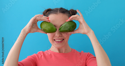 Cheerful Woman Making Avocado Eyes blue background © demphoto