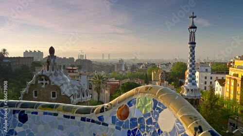 Crane shot of Barcelona city view from Guell Park. Sunrise view of colorful mosaic building in Park Guell. UHD, 4K photo