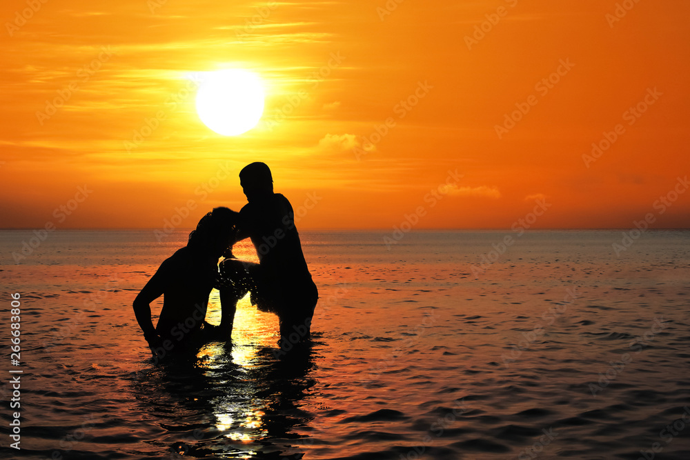 Asian man practicing Thai boxing on the sea beach at sunset. Asian man practicing Thai boxing on the sea beach at sunset.
