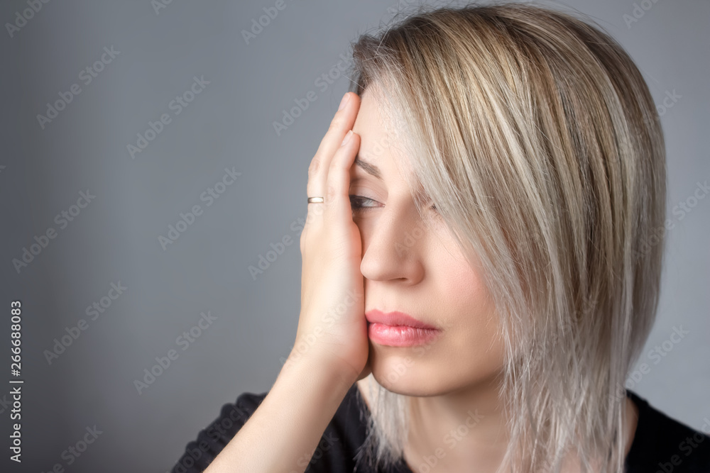 A sad woman with a ring on her hand presses her hand to the beating. Victim. Domestic violence against women and abuse of power in marriage concept. Stop sexual abuse. Copy space. A sad woman with a ring on her hand presses her hand to the beating. Victim. Domestic violence against women and abuse of power in marriage concept. Stop sexual abuse. Copy space.