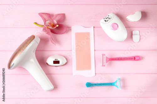 A set of different hair removal products on a wooden table. Removal of unwanted body hair at home.
