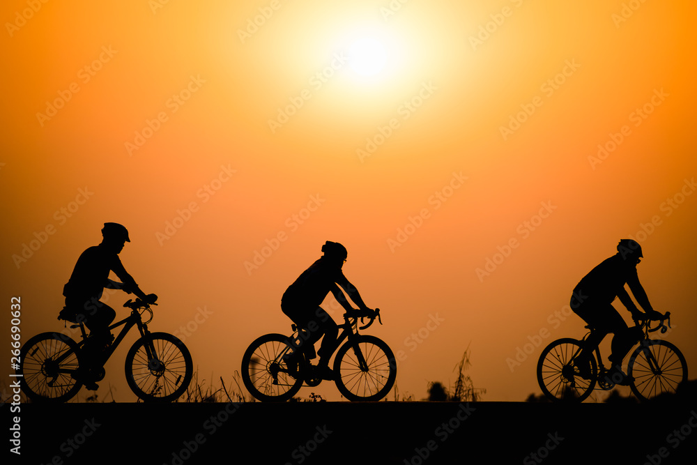 Fototapeta premium Silhouette man cycling on sunset background