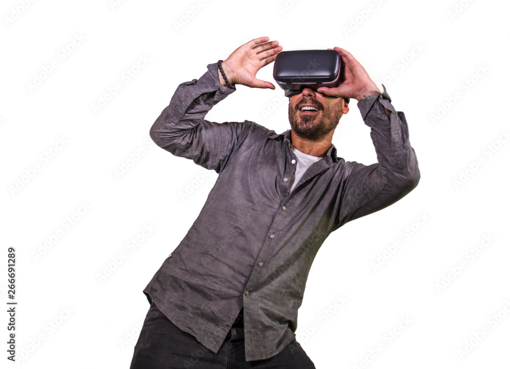 young happy and excited man wearing virtual reality VR goggles headset experimenting 3d illusion playing video game touching illusion environment surprised young happy and excited man wearing virtual reality VR goggles headset experimenting 3d illusion playing video game touching illusion environment surprised
