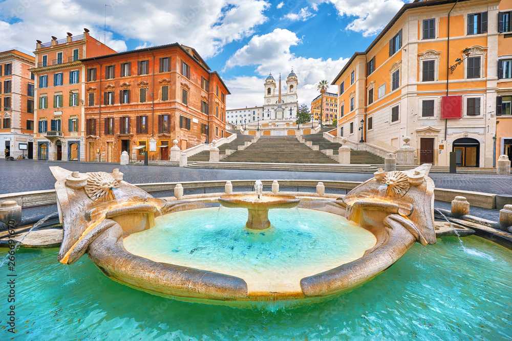 Rome, Italy. Fountain of the Boat (Fontana della Barcaccia) on Spanish square (Piazza di Spagna) at the bottom of Spanish stairs famous landmark design by Bernini. Summer day and blue sky with clouds.