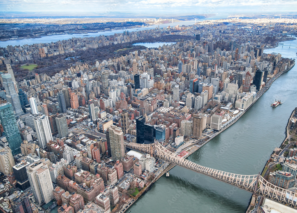 New York City from helicopter point of view. Queensboro Bridge with Manhattan skyscrapers on a cloudy day