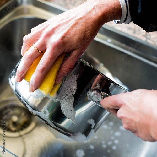 Woman Washing Up a Saucepan in the KIchen Sink photo