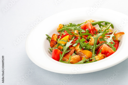 Salad with anchovies and sweet pepper, with croutons and arugula. On white background