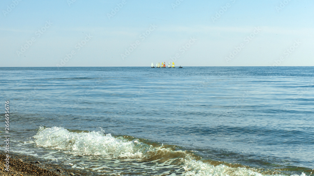 sailboats on the horizon are sailing on the blue sea sailboats on the horizon are sailing on the blue sea
