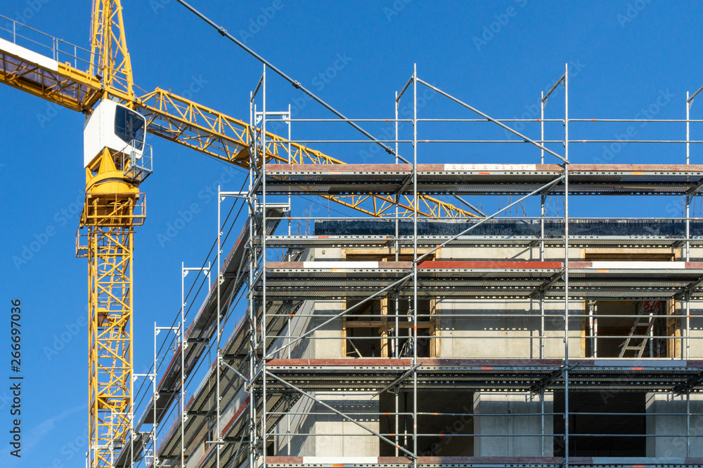 building under construction - construction site with scaffolding at the outside