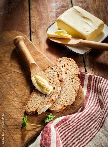 Pat of farm butter with slices of rye bread