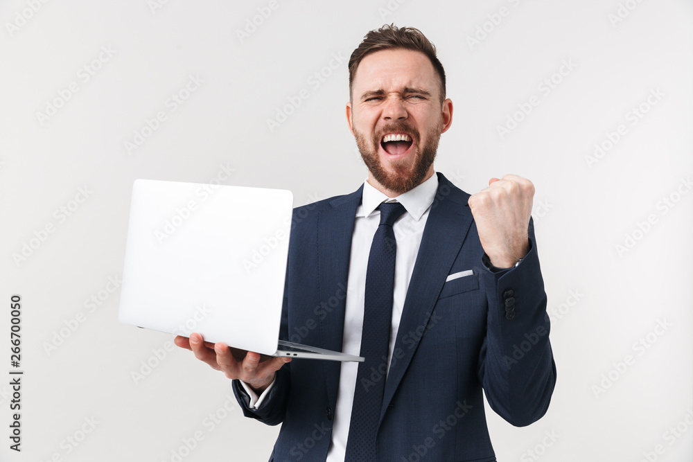 Excited businessman posing isolated over white wall background holding laptop computer. Excited businessman posing isolated over white wall background holding laptop computer.