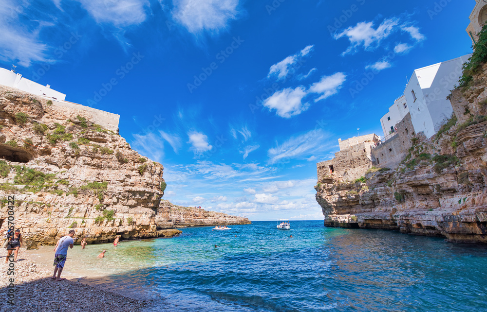 POLIGNANO A MARE, ITALY - SEPTEMBER 16, 2014: People enjoy city beach on a beautiful summer day. The city is a famous tourist attraction in Apulia