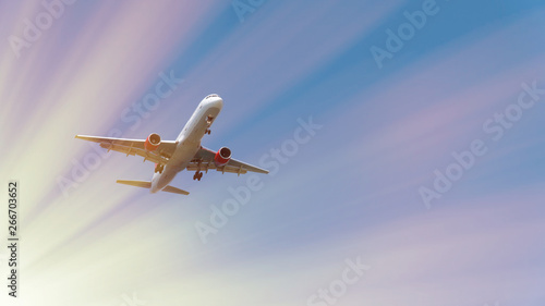 Passenger airplane in blue sky. Commercial plane is landing. Fast Travel and transportation concept. At sunset