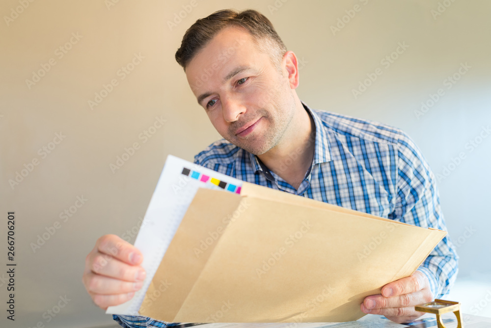 smiling man opening a letter with printing smiling man opening a letter with printing