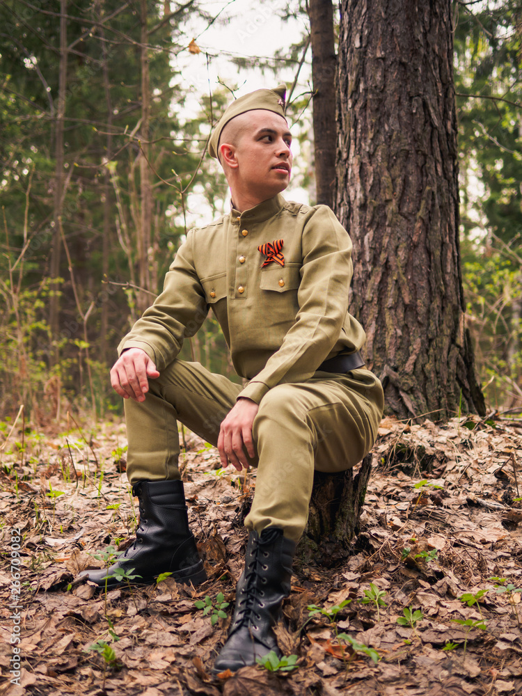 Man in soviet war uniform in forest. Victory day reenactment