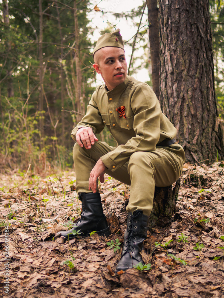 Man in soviet war uniform in forest. Victory day reenactment