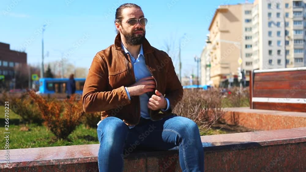 Transfer bribes in the street. A man gives money in an envelope to another man while sitting on the bench in the park Transfer bribes in the street. A man gives money in an envelope to another man while sitting on the bench in the park