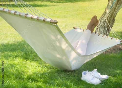 Feet of black woman lying in hammock in a garden © luaeva