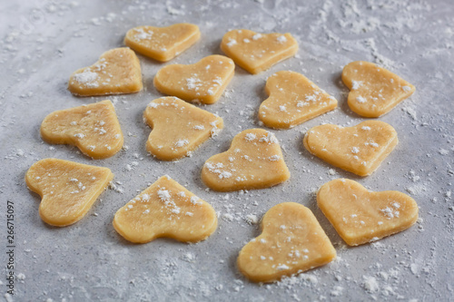 Raw dough cookies in the shape of hearts. The process of making cookies and gingerbread at home. pattern side view