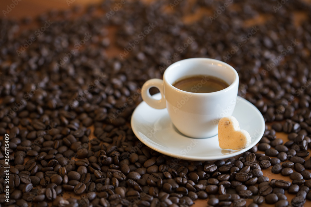 cup of coffee and beans on wooden table cup of coffee and beans on wooden table