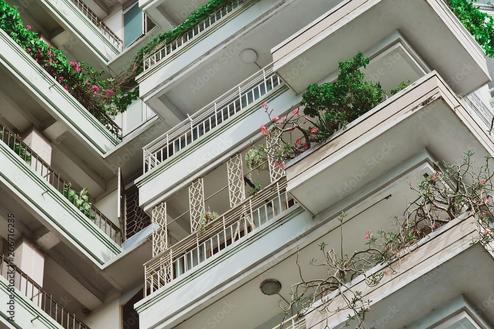 modern ecological building with lots of plants on the balcony
