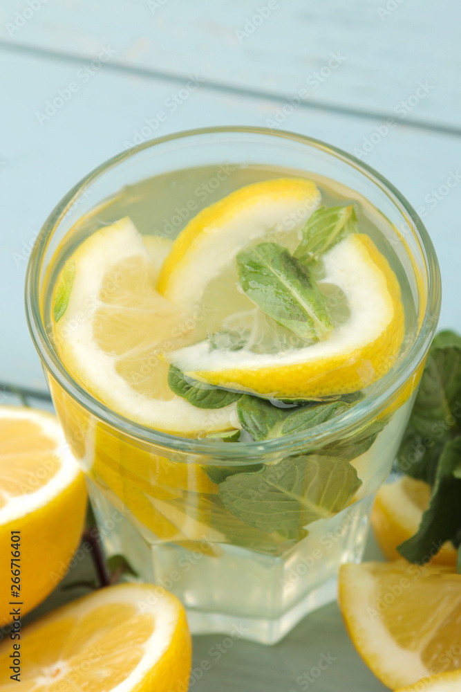 Homemade lemonade with mint and lemon in plastic glasses on a blue wooden background. Refreshing lemonade drink. close-up Homemade lemonade with mint and lemon in plastic glasses on a blue wooden background. Refreshing lemonade drink. close-up