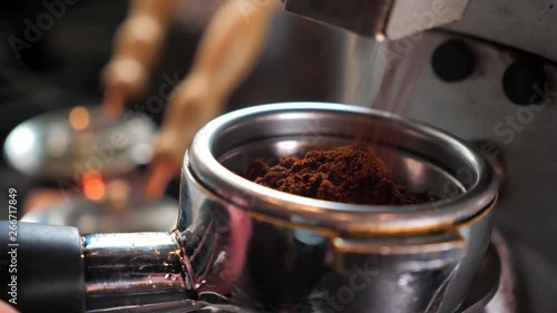 Closeup shoot of coffee beans being freshly grinded in a coffee blending machine indoors in a cafe