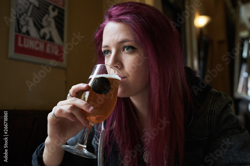 Emo girl drinking alone in the pub slowly