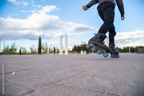 Closeup of legs with roller skates in action in beautiful city park