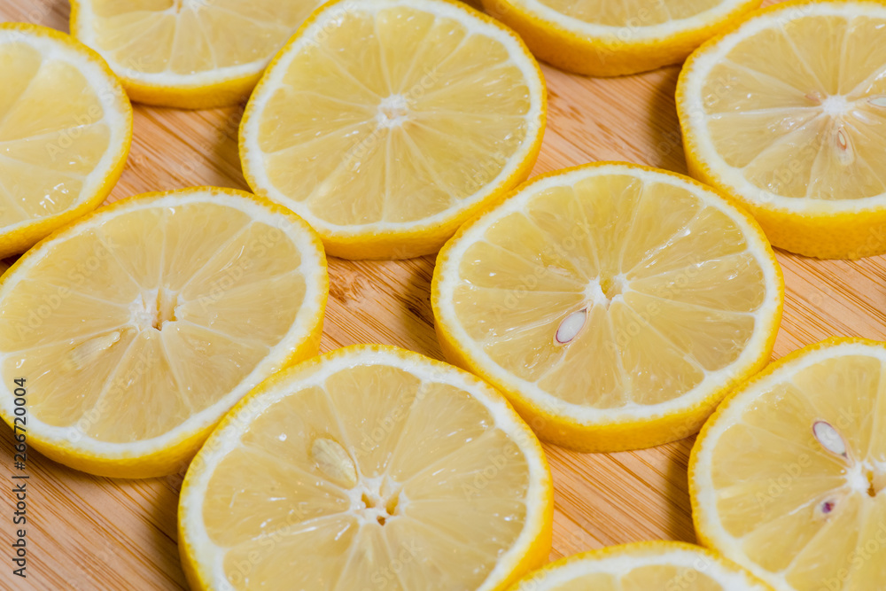 Fresh yellow lemons slices on a wooden background.. sweet lime, vitamin c. Lemon slices Fresh yellow lemons slices on a wooden background.. sweet lime, vitamin c. Lemon slices