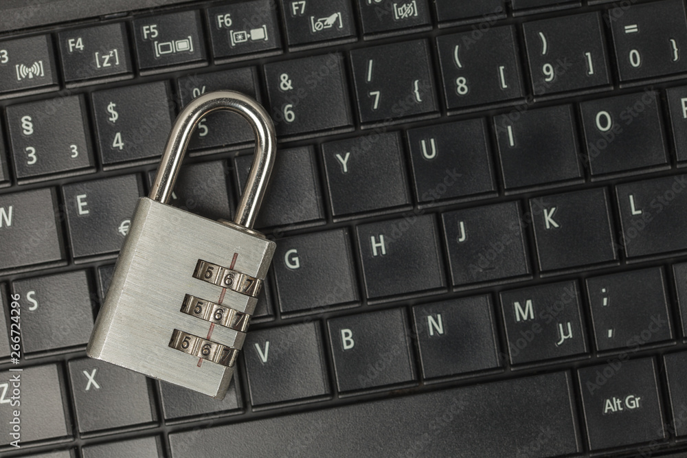 Locked code padlock on black laptop keyboard with copy space Locked code padlock on black laptop keyboard with copy space