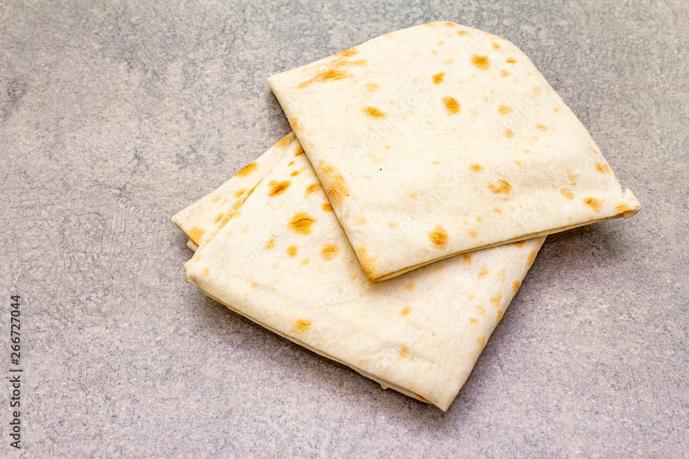 Pita bread lavash on a stone background. Food cooking background, wallpaper.