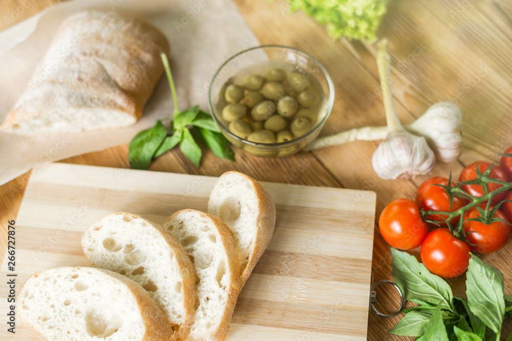 Sliced bread, ciabatta on wooden background. Preparation for the preparation of bruschetta. Sliced bread, ciabatta on wooden background. Preparation for the preparation of bruschetta.