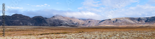 Landscape panoramic panorama view of Laugarvatn mountains with clouds covering on golden circle in Iceland during day and blue color sky in autumn